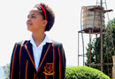 A girl in a school uniform smiles contentedly