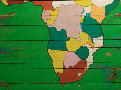 A colourful, hand-painted map of Africa on a green wooden wall