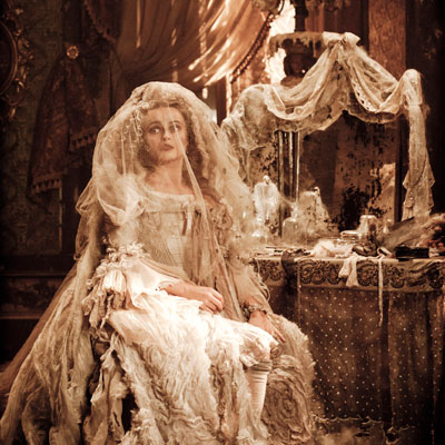 long shot of Miss Havisham in her dishevelled wedding dress in front of her dressing table