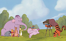 Animated image of a tiger taking a photograph of a bear, kangaroo, donkey, rabbit, two elephants and a pig
