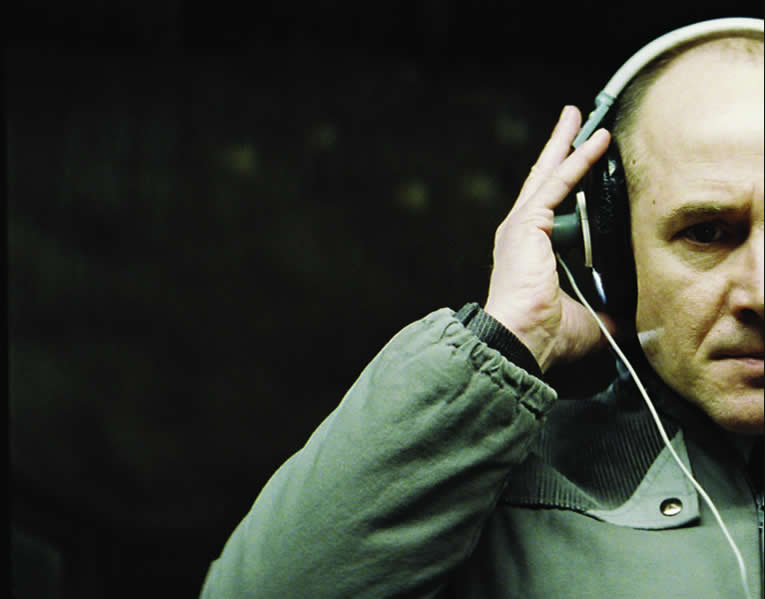 Still from the film, showing Captain Wiesler listening intently to headphones