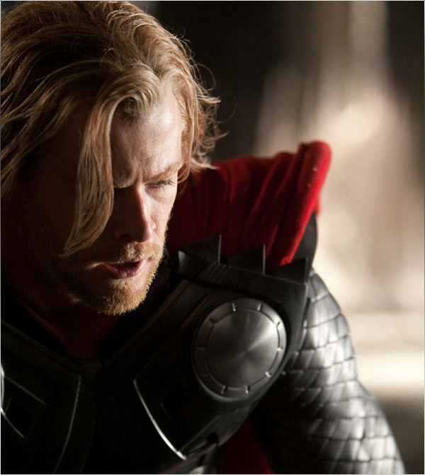 Medium close-up shot of a man in armour and cloak. He has long blond hair.