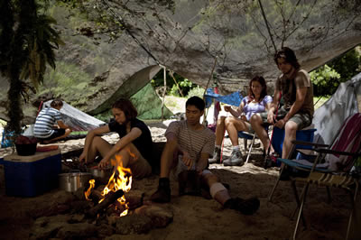 A group of young people at a campsite covered with a net