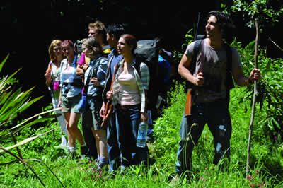 A group of young people stand in a line in a jungle scene