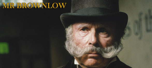 Close up shot of Mr Brownlow, who wears a tall hat and has large whiskers