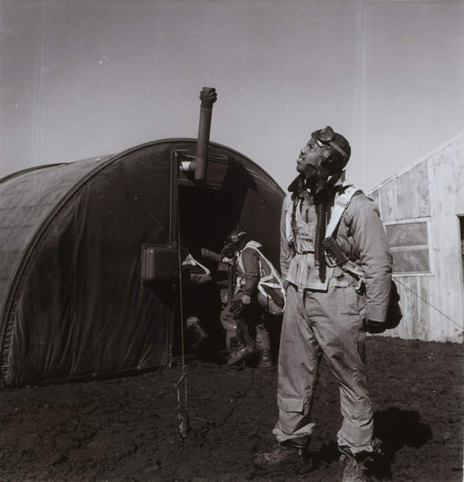 Pilot scanning the skies with parachute room in background